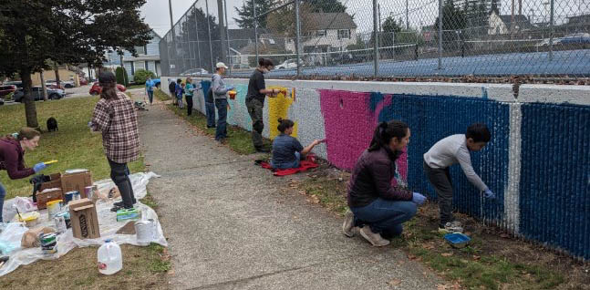 Bayside residents paint the tennis court wall in Clark Park